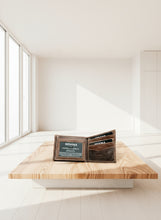 Load image into Gallery viewer, Brown leather wallet with card slots on a white surface in a minimalistic room with large windows.